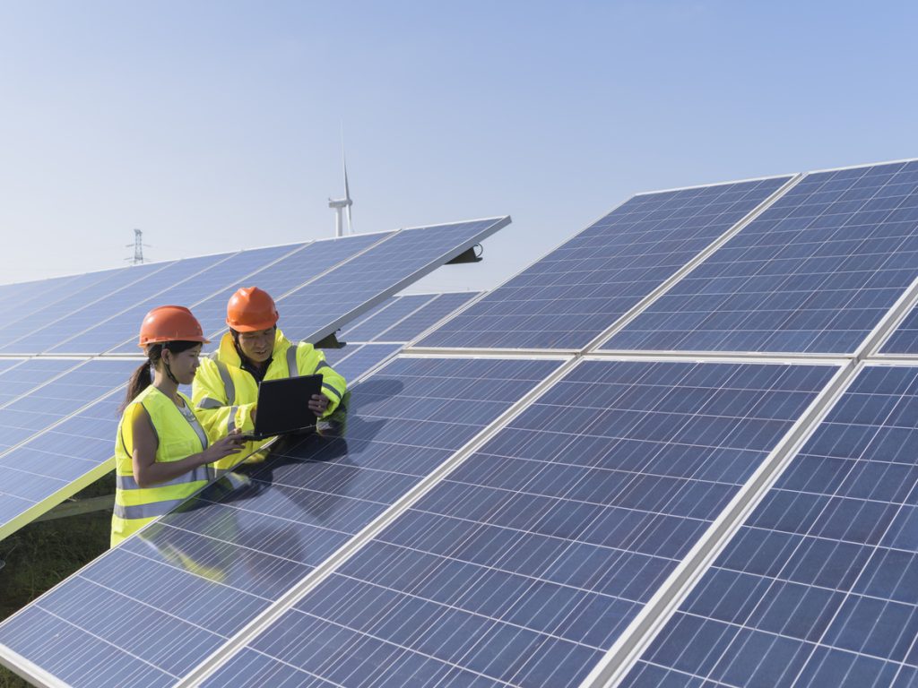 workers at a renewable energy plan, young asian engineers  working in  solar power station.